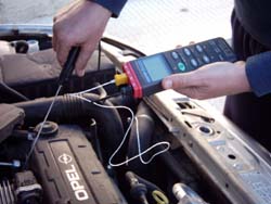 the PCE-T395 contact thermometer measuring the temperature of a car motor