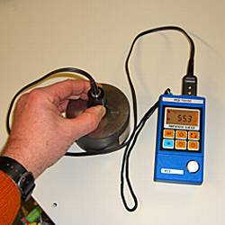 the PCE-TG100 thickness gauge measuring a steel plate