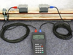 The PCE-TDS 100H ultrasonic model of Flow Testers measuring a pipe