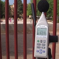 Decibel meters taking a measurement in the street with a decibel meter.