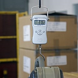 Hanging balance weighing a suit-case.