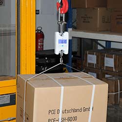 Hanging scales PCE-HS N Series weighing a briefcase to be shipped by a carrier company.