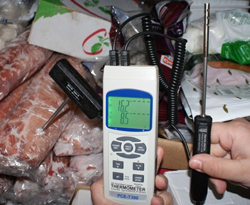 The PCE-T 390 digital thermometer measuring refrigerated products in a cooling chamber.